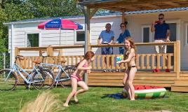 Famille devant mobil home au camping de Oase